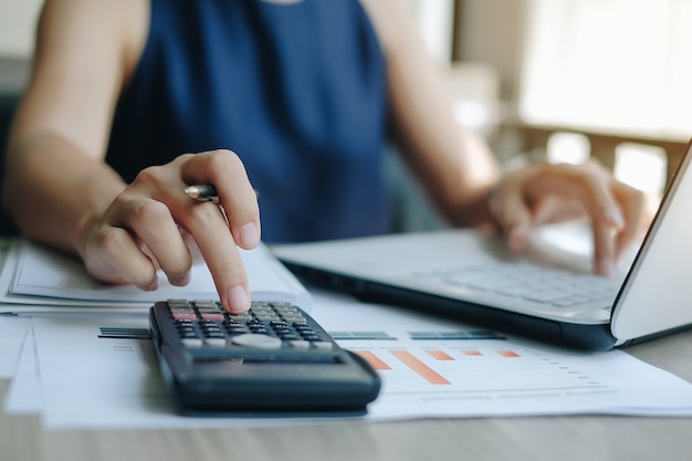 Businesswoman using calculator for analysis marketing plan