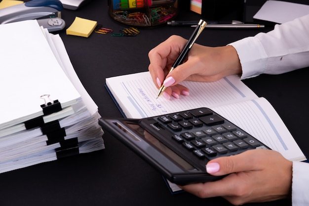 Businesswoman using a calculator on the desk