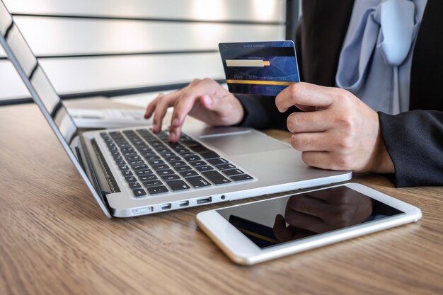 Businesswoman using laptop and holding credit card for paying detail page display online shopping