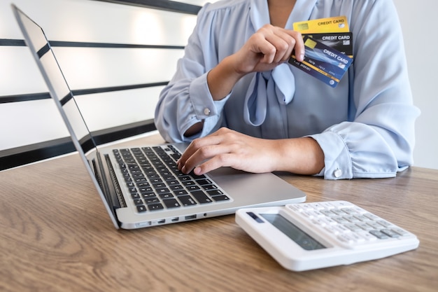 Businesswoman using laptop and holding credit cardng