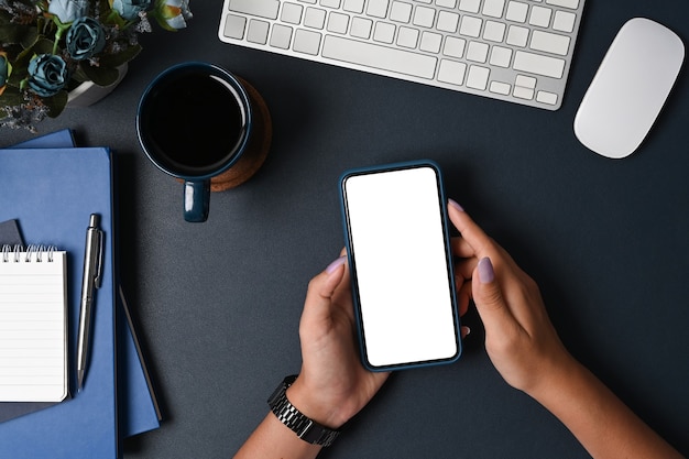 Businesswoman using smart phone on black background.