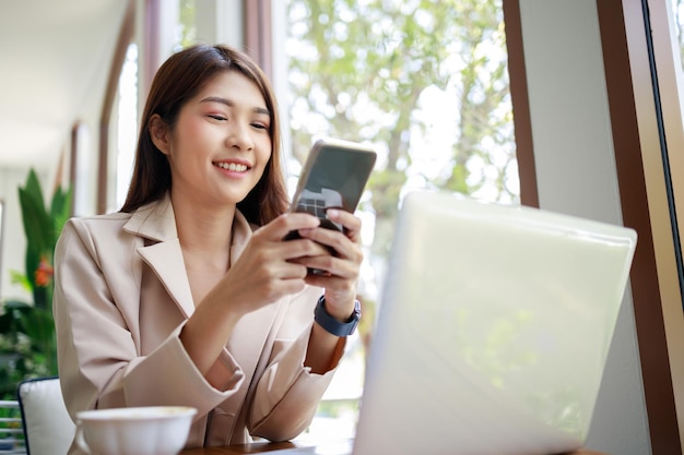 Businesswoman using smartphones and working by laptop in the coffee shop