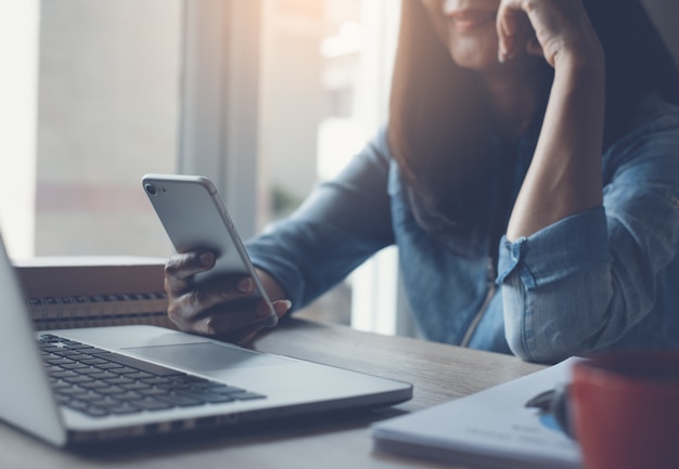 Businesswoman video calling via smartphone working in office