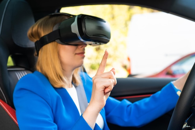 Businesswoman in the vr googles sitting in the car and turning the steering wheel in a car having an