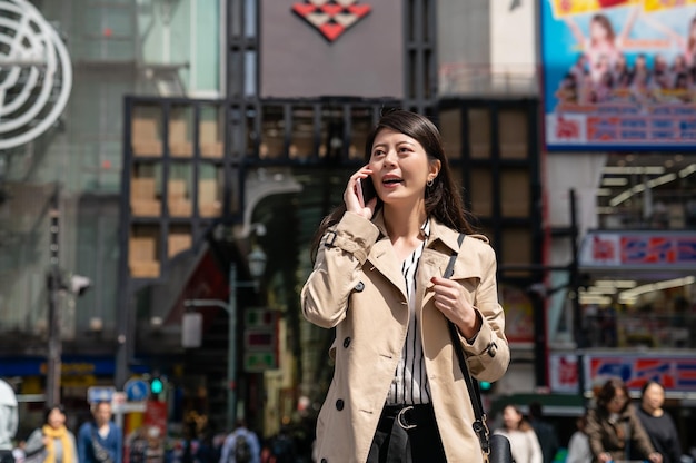 businesswoman waiting her friend on the street and calling her to check when will she arrive