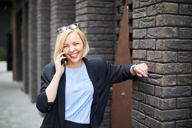 Businesswoman walking across the street talking on smart phone