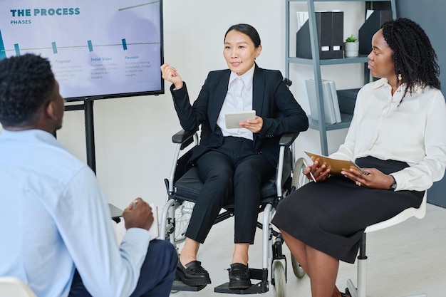 Businesswoman with disability giving report for colleagues