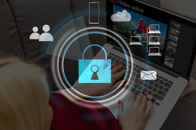 Businesswoman with laptop, desktop at office interior, blue glowing information protection icons. Padlock and business data symbols. Concept of cyber security and data storage.