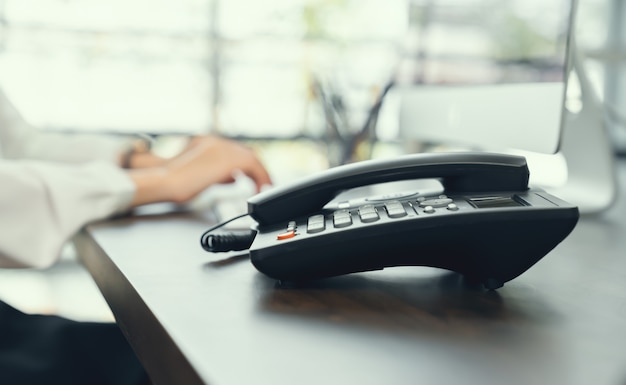 Businesswoman working on computer and office phone on the desk.&#x9;