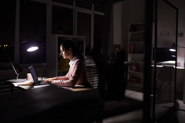 Businesswoman working n dark office