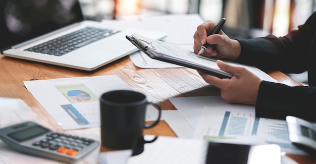 Businesswoman working at office with document on her desk doing planning analyzing the financial report