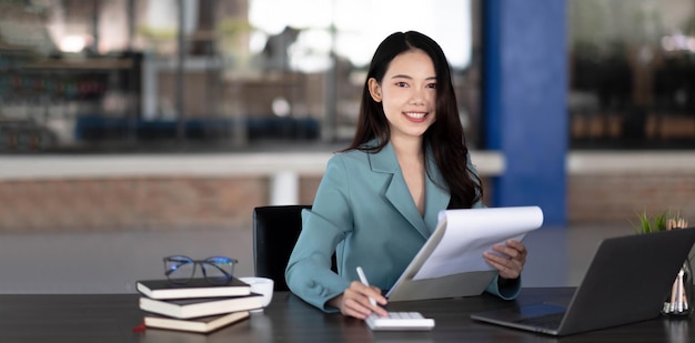 Businesswoman working with laptop computer and looking information on digital tablet.