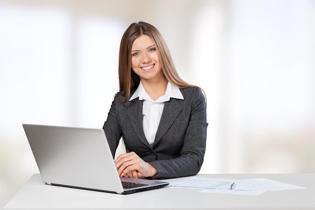 Businesswoman working with laptop and smiling at camera