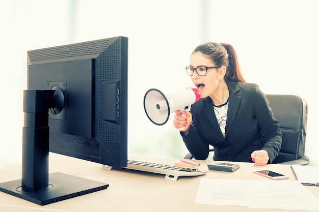 Businesswoman yelling through a megaphone