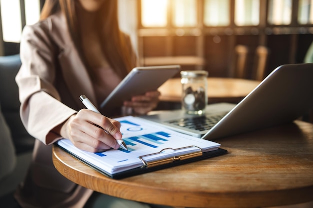 Businesswomen analyzing investment graph and discussing plan in office room