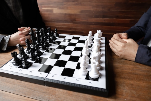 Businesswomen play chess on board challenges planning business strategy to success concept