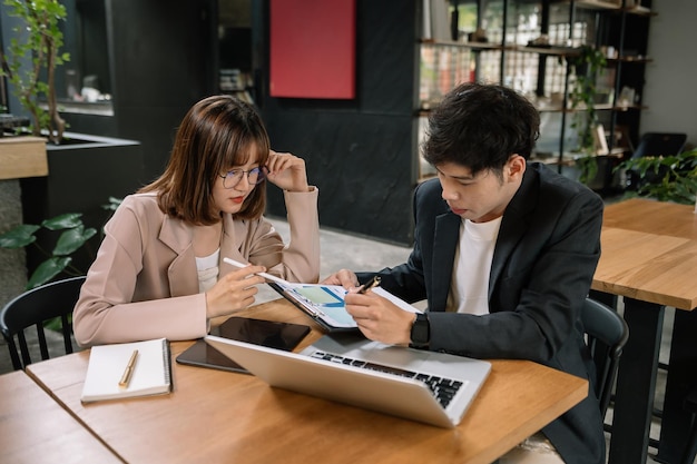 Businesswomen work and discuss their business plans A Human employee explains and shows her colleague the results paper in officexA