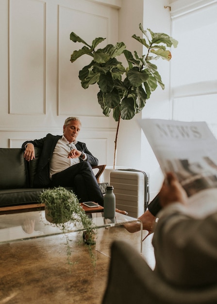 Busy businessman with a suitcase looking at the time