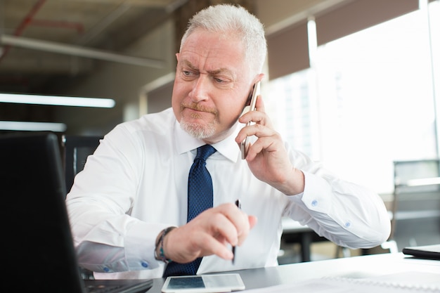 Busy executive reading email and talking on phone