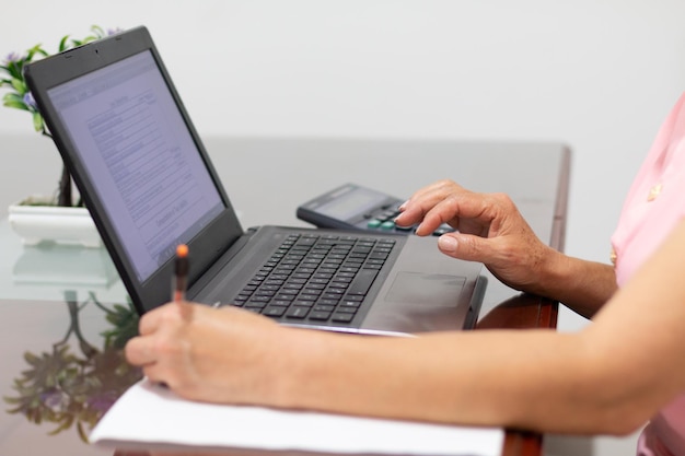 Busy hands Multitasking woman doing her taxes from her laptop