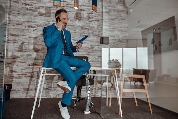 Busy happy adult man chatting on his mobile phone