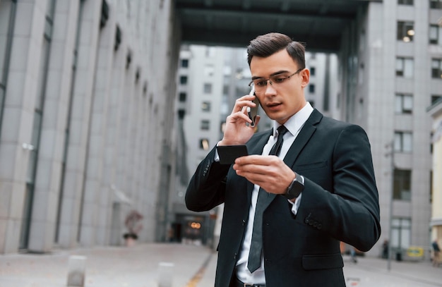 Busy man Businessman in black suit and tie is outdoors in the city