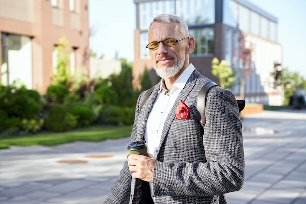 Busy man portrait of confident stylish middle aged businessman in sunglasses looking at camera