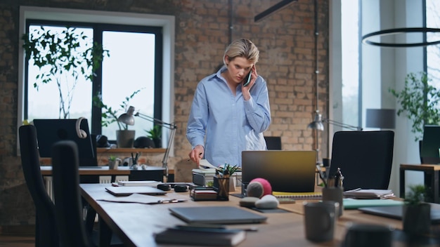 Busy woman speaking mobile phone at modern office serious businesswoman calling