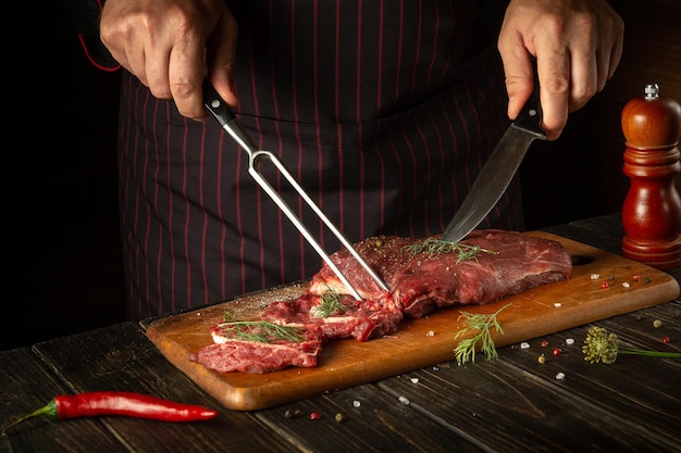 Butcher or chef preparing raw fresh beef meat on cutting board before baking or barbecue