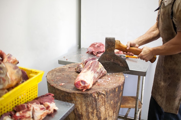 Butcher chopping meat with an axe