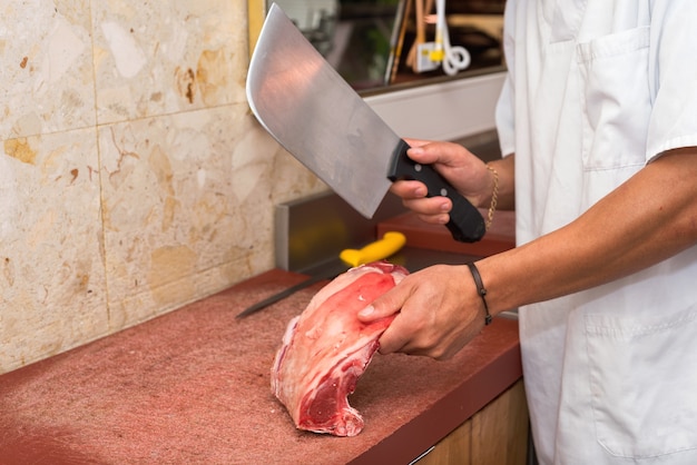 Butcher cutting steaks at the butcher shop