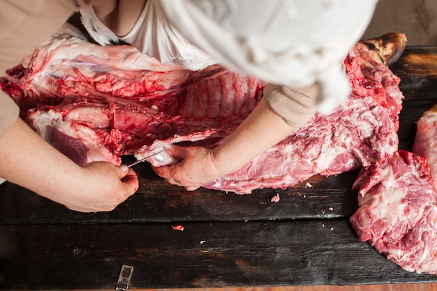 Butcher slicing piece of pork carcass