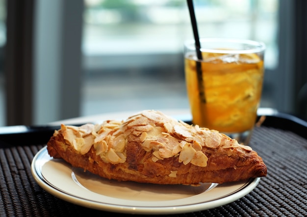 Butter almond croissant with iced tea background