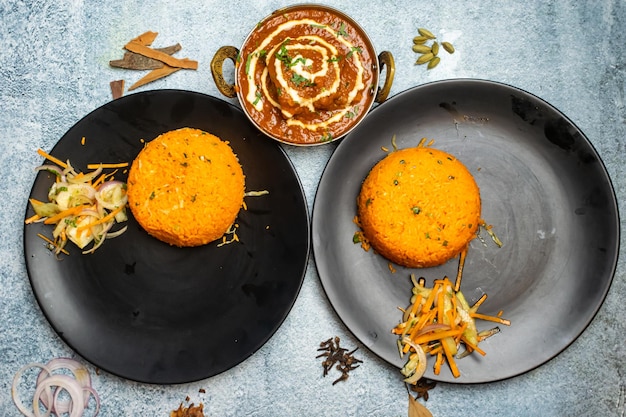 Butter chicken masala and Zyro Rice or gyro with chili sauce served in a dish isolated on grey background top view of bangladesh food