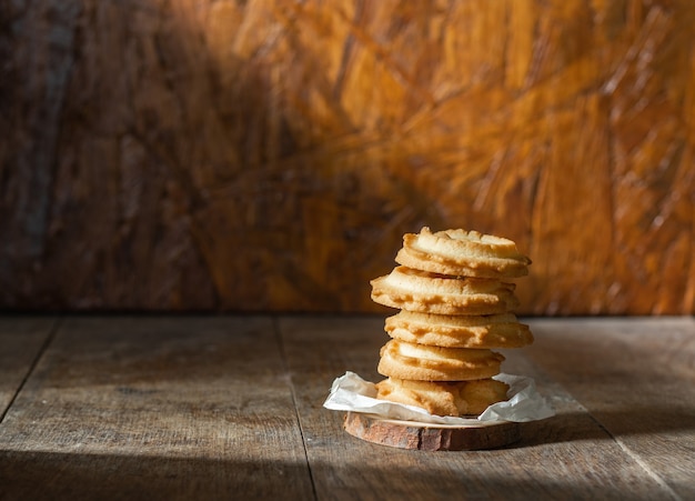 Butter cookies stacked on a wood table background.