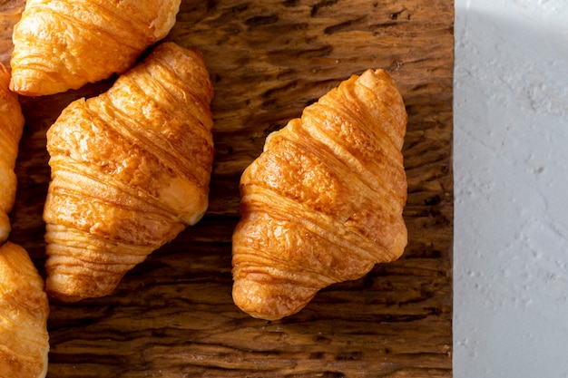 Butter croissants on a rustic wooden board.