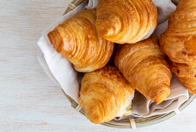 Butter croissants in small wicker basket. top view