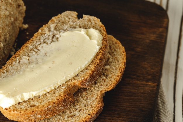 Buttered slice of rye bread on wooden table