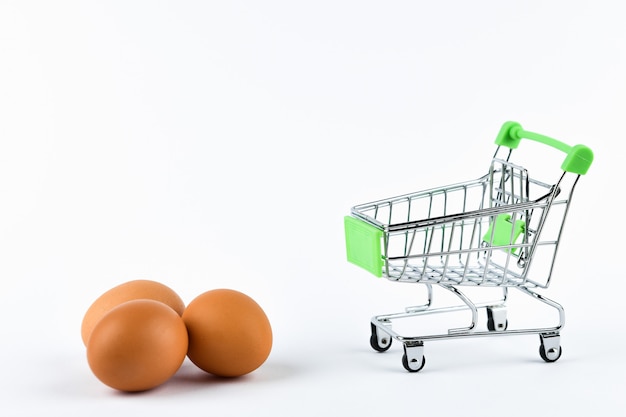 Buying eggs trading concept. Shop online. Basket and eggs on white