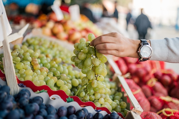 Buying fresh grapes at farmers market.