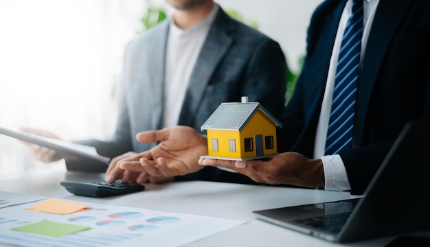 Buying a home or insurance deal an insurance agent pointing a pen to those interested in renting a house a contract signing an Home buying agreement