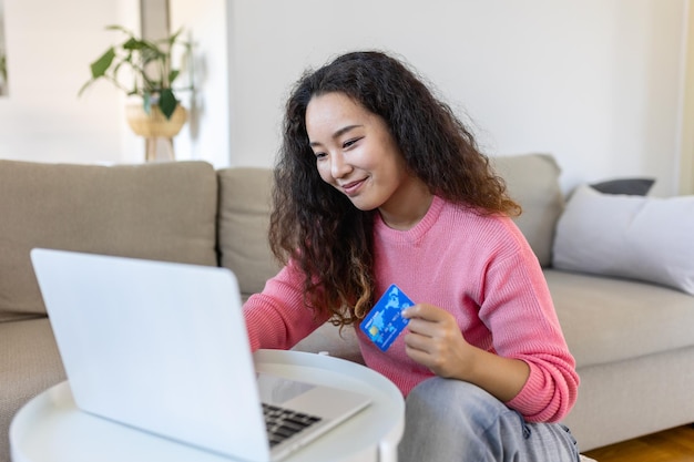 Buying on internet lifestyle Happy Asian woman shopping online with laptop at home