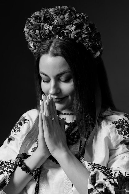 BW Portrait of ukrainian woman in traditional ethnic clothing and floral red wreath on studio background Ukrainian national embroidered dress call vyshyvanka Pray for Ukraine