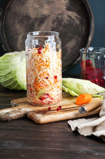 Cabbage fermented sauerkraut in glass jar on table in kitchen closeup Fermented preserved vegetarian food