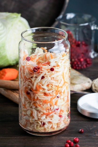 Cabbage fermented sauerkraut in glass jar on table in kitchen closeup Fermented preserved vegetarian food