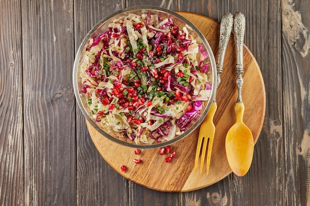 Cabbage salad of two colors with pomegranate seeds and salted nuts. French gourmet cuisine. Flat lay