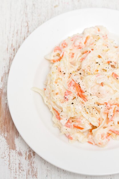 Cabbage salad on white plate on wooden surface