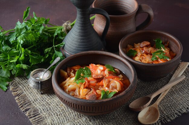 Cabbage stew with grilled sausage in tomato sauce