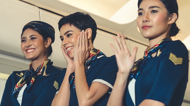 Cabin crew dancing with joy in airplane