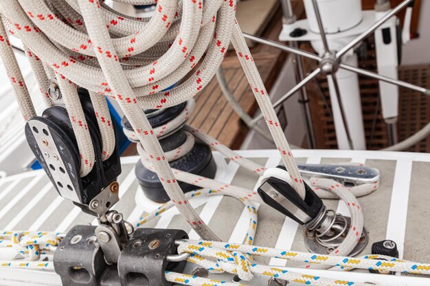 Cabin of a sailing yacht with a steering wheel rollers for attaching sail ropes and ropes